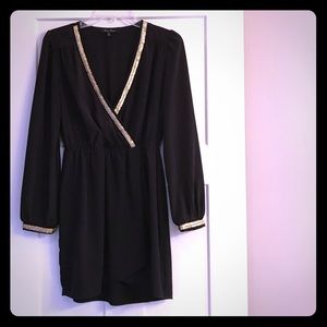 Black mini, long sleeve dress with gold detail.